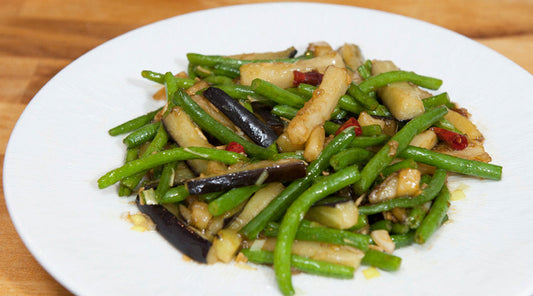 Aubergine met sperziebonen geroerbakt in een wok
