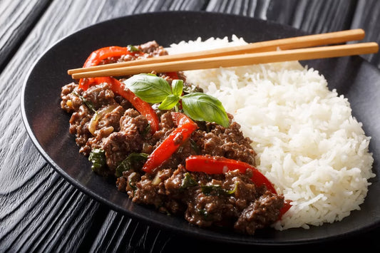 Thais roergebakken rundvlees met Thaise basilicum en jasmijnrijst in een wok