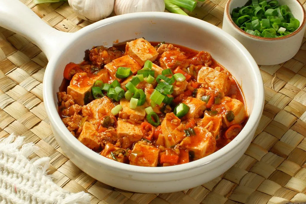 Gestoomde zijdetofu op Kantonese wijze met gember, lente-ui en koriander, overgoten met hete saus