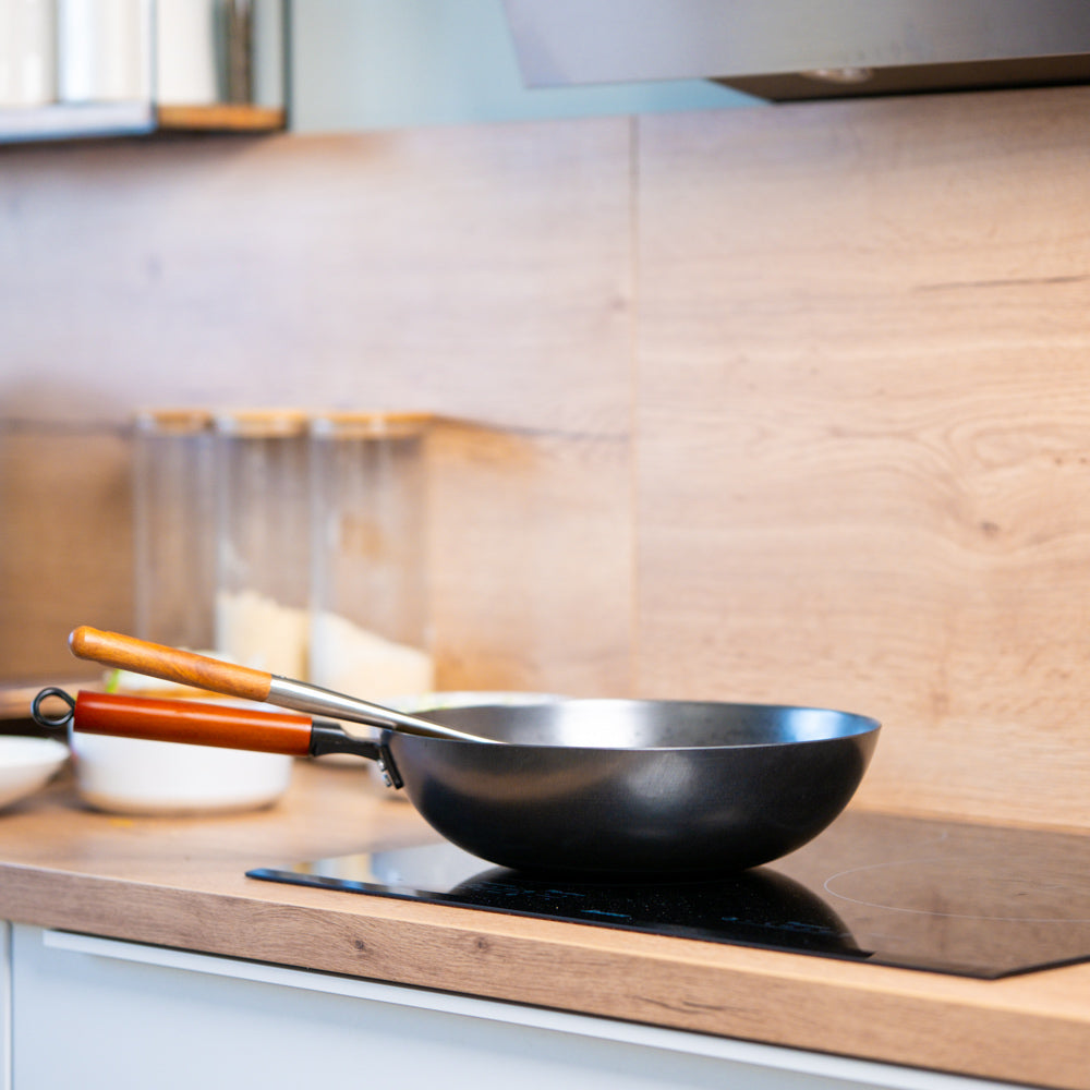 Le Oniri plaatstalen wok inductie roerbakt groenten op inductiekookplaat