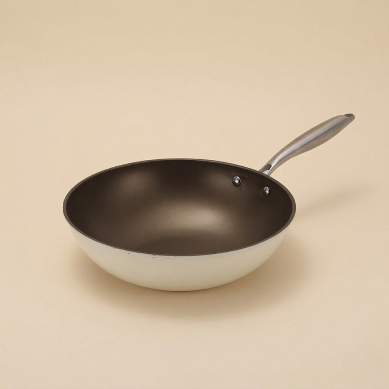 Le Yorano gietijzer oppervlak van de witte wok in detail close-up