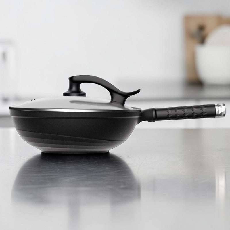 Le Takino zwart aluminium wok met deksel op kookplaat in gebruik