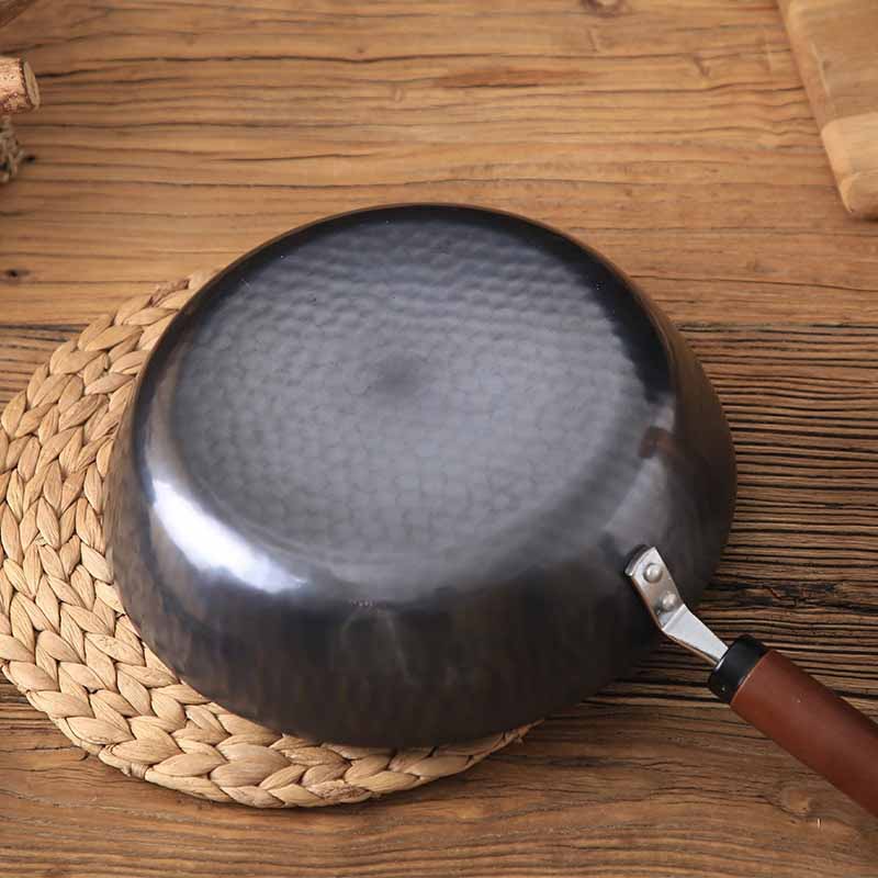 Le Pekaji smeedijzeren wok zonder coating in gebruik op gasfornuis