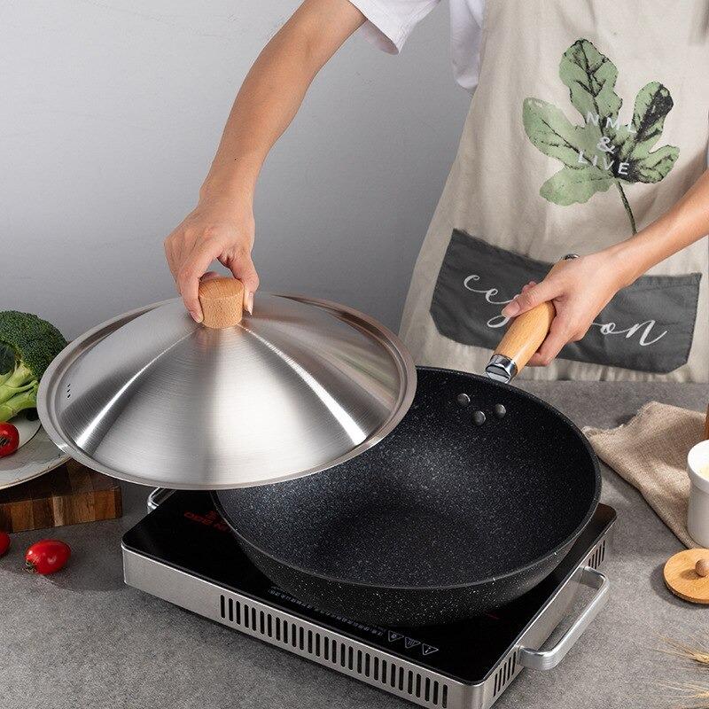 Le Aino keramische wok met deksel tijdens het roerbakken op kookplaat