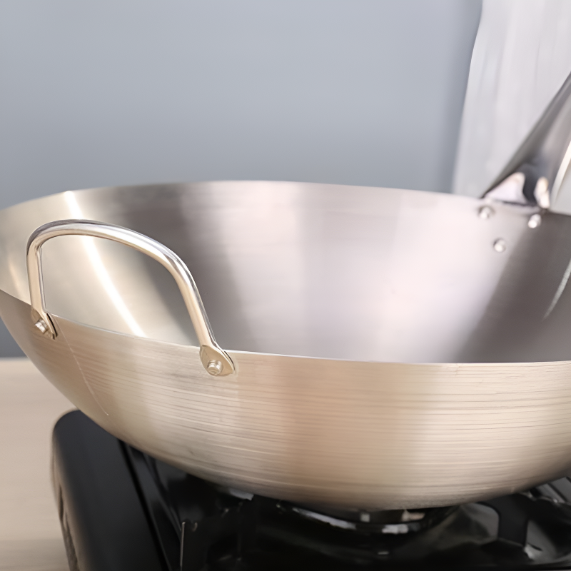 Le Asama rvs wok 32 cm detailopname van gelast stalen handvat