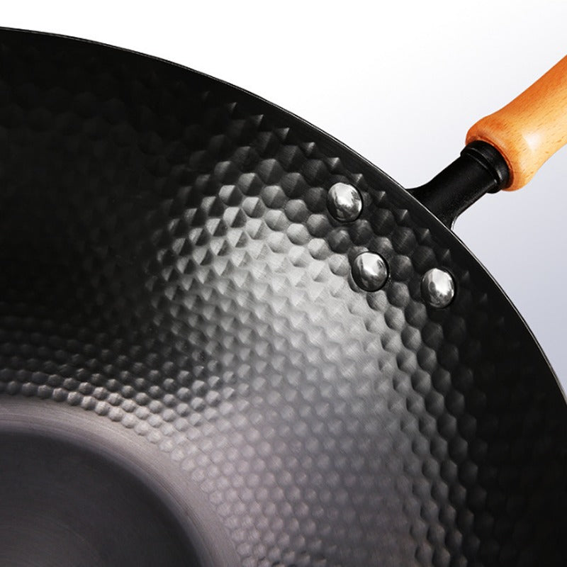 Le Kumichi koolstofstaal wok detail gehamerd oppervlak en houten handvat